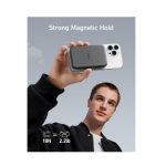 Person holds up a smartphone with a magnetic attachment labeled 'Strong Magnetic Hold' against a gray sky, with 10N and 2.2 lb icons shown.