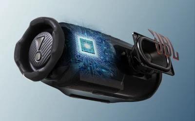 Cutaway illustration of a speaker revealing a blue circuit board and microchip inside, symbolizing advanced audio tech there.