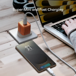 Smartphone charging on a wooden desk with a fast charger and a laptop nearby.