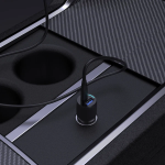 Close-up of a USB charging port installed in a vehicle's center console, with a cable plugged into a blue-lit USB-A/USB-C port and surrounding cup holders.
