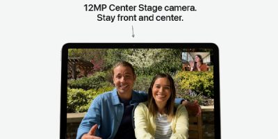 Tablet screen shows a video call with a smiling couple on a bench; a small inset video shows another participant.
