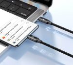 Smartphone connected to a laptop with two braided cables plugged into USB-C ports, with file icons projected on the desk surface.